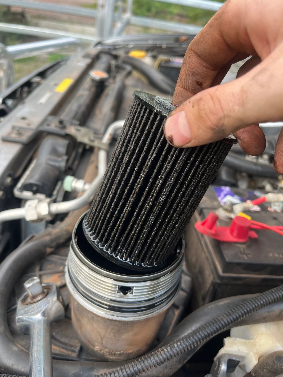 Hand checking an engine air filter during the Nissan Patrol service.