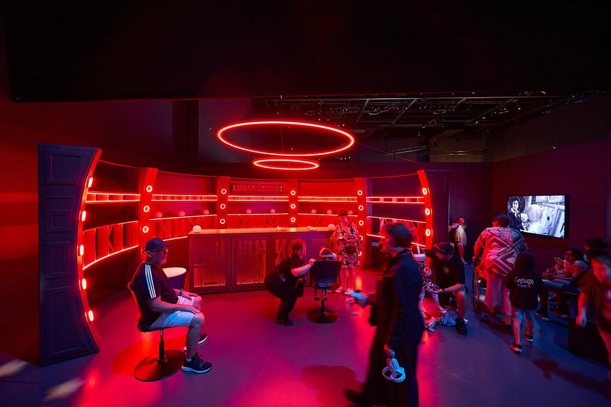 View of the red-lit To The Moon event space, with circular overhead lighting.