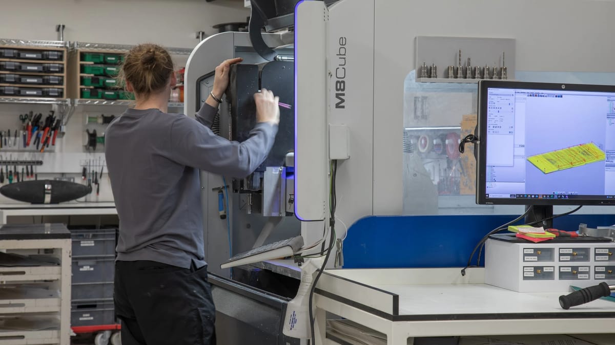 Designer Toby Allen working at a CNC router in his workshop.