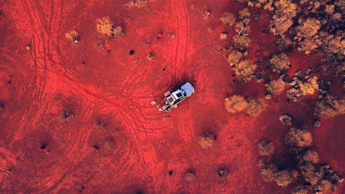 Aerial view of Toby Allen’s Nissan Patrol camper on a red dirt track in Western Australia.