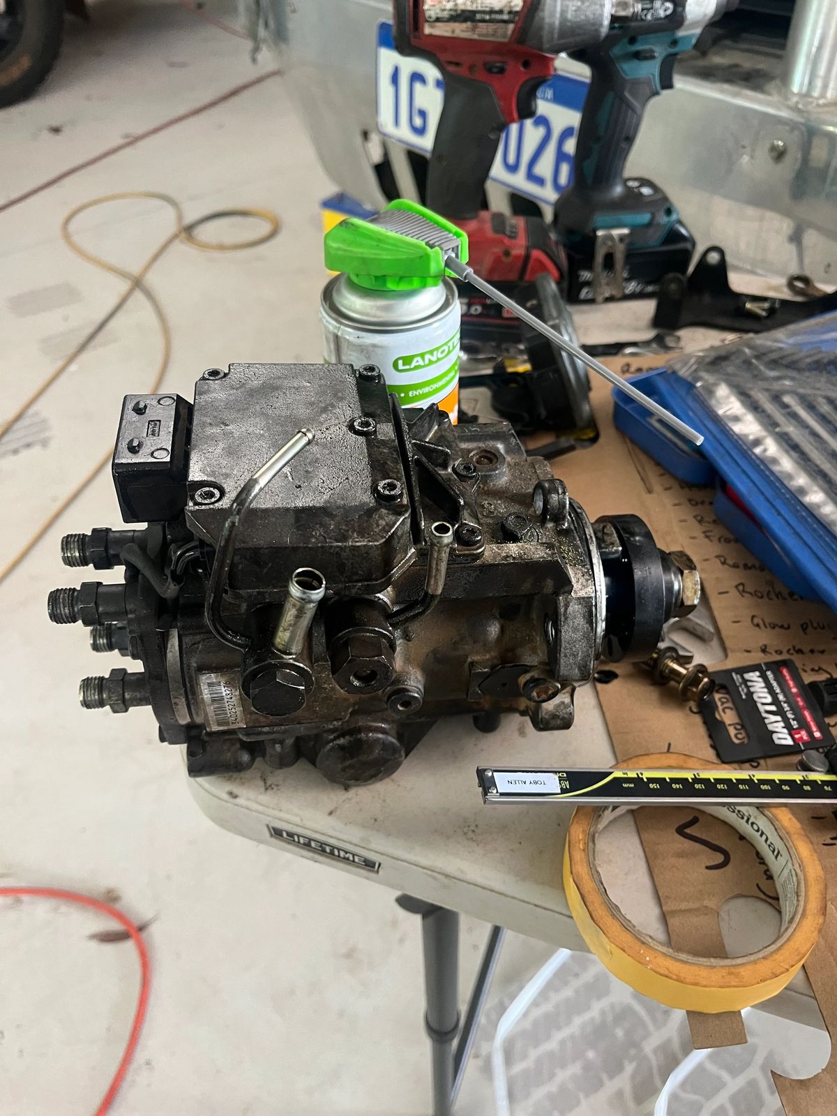 Removed engine component laid out on the workshop floor for repair.